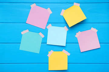 Paper sticky notes on blue wooden table