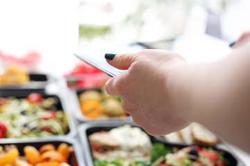 Dietary catering, balanced box diet. Ready lunch boxes in the kitchen. The woman photographs the products