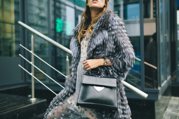 stylish woman in winter fur coat walking in street