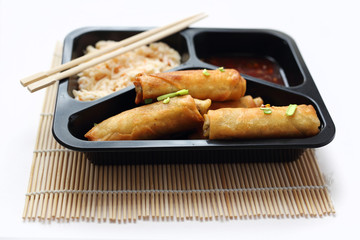 Spring roll fried in soy sauce and salad. Ready food from the store packed in a take-out box