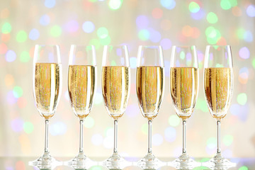 Glasses of champagne on blurred lights background
