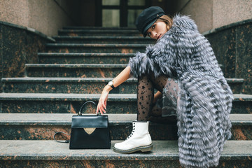 stylish woman in winter fur coat walking in street