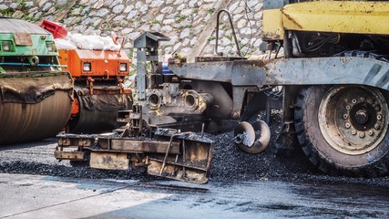 Industrial pavement, road construction works with roller compactor and asphalt finisher machines / vehicles.
