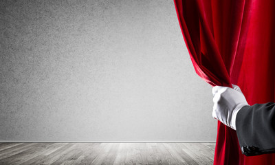 Concrete wall behind drapery curtain and hand opening it