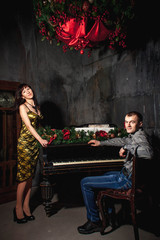 Fototapeta na wymiar couple at the piano with Christmas decor