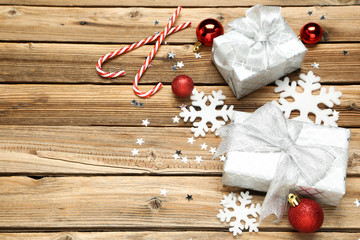 Gift boxes with christmas ornaments on brown wooden table