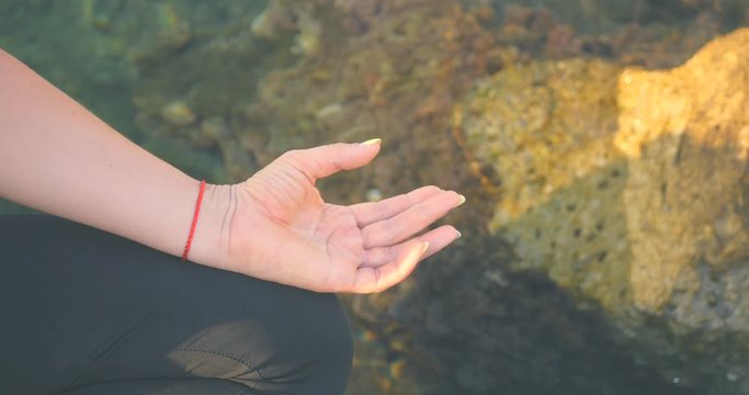 Finger mudras in lotus pose near the sea