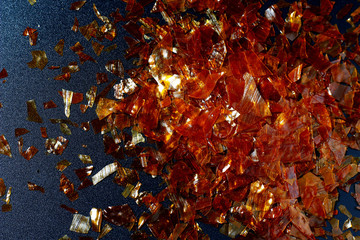 flakes of shellac varnish in a beam of light on a dark background