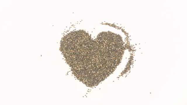 Closeup of woman's hands forming heart from chia seeds in backward play