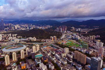 an aerial view of downtown districts of shenzhen city under heavy dark clouds during summer sunrise