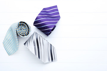 Colored neckties on white wooden table