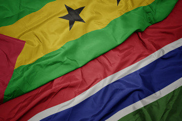 waving colorful flag of gambia and national flag of sao tome and principe .