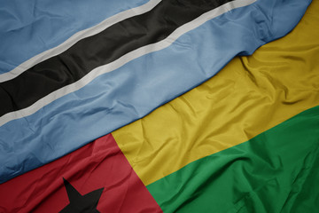 waving colorful flag of guinea bissau and national flag of botswana.