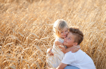 Naklejka na ściany i meble boy and girl hugging in wheat field