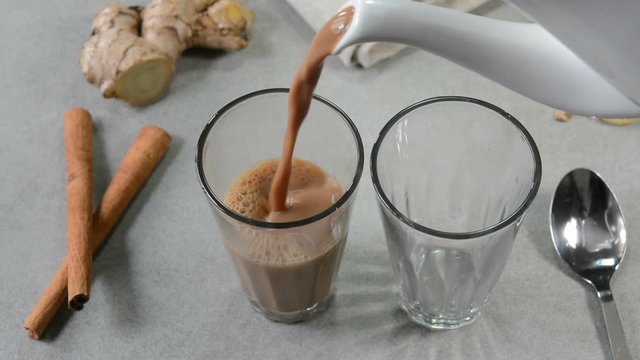Pouring ginger cinnamon tea chai in glass tea cups