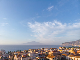 Fototapeta premium Aerial view on the center of Sorrento city, sunset, houses and streets, sea views and a Vizuvius, Napoli in the distance. Travel and vacation concept on Italy. Infrastructure. Copy space