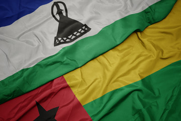waving colorful flag of guinea bissau and national flag of lesotho.