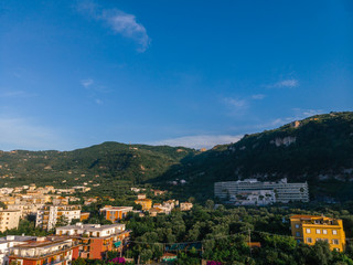 Fototapeta na wymiar Aerial view on the Sorrento city streets, sunset, houses and Hotels, mountains and buildings in the distance. Travel and vacation concept on Italy. Infrastructure, cars and parking place