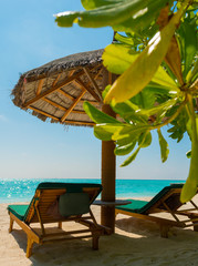 Resting on the beach with a green sun bed and a wonderful beach with aquamarine water 