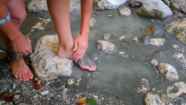 Woman smearing mud mask on her feet