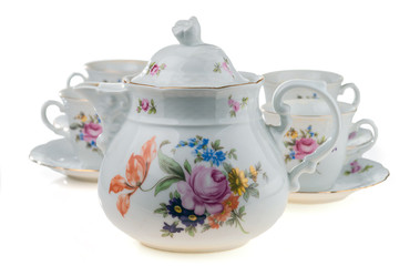 Porcelain teapot with cups on a white background. Selective focus.