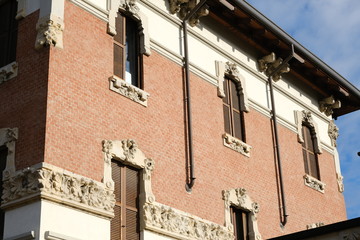 Art Nouveau building in the city of Busto Arsizio. Brick facade and floral decorations.