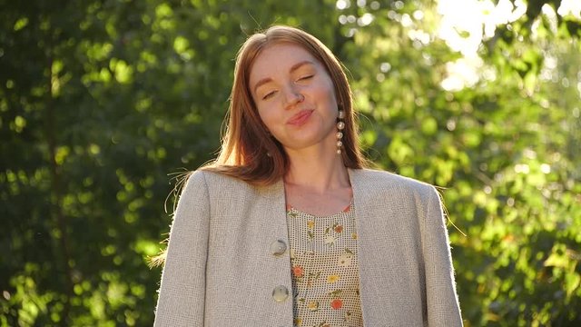 Beautiful young woman in park on sunny day. Slow motion effect