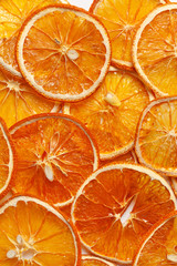 Background of dried orange slices. Fruit snacks or dehydrated crispy slices. Vegetarian food. Fruit chips