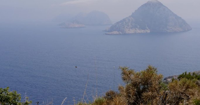 View to an unhabited islands through the trees in Gelidonya cape in Mediterranean sea, Antalya, Turkey. Windy weather.