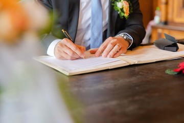 Grooms signs wedding contract, beautiful hands, luxury watch