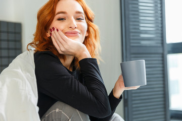 Red hair attractive young woman close up portrait with cup of tasty coffee