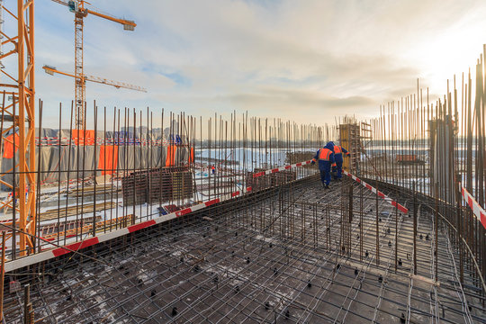 Construction of reinforced concrete base plate of monolithic residential complex. Reinforcement work, installation of formwork. Concrete is 