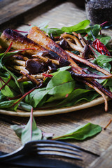 Plant based food, roasted parsley root with mushrooms and fresh baby chard leaves