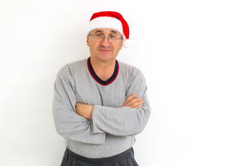 portrait of senior man in santa hat looking at camera and winking over light white background
