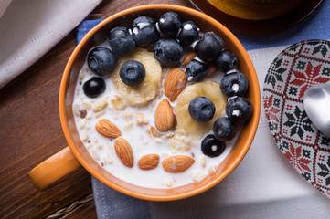 funny kids oatmeal porridge with blueberries, fruits,  almonds and coconut milk. Healthy and tasty vegan breakfast. top view, flat lay.