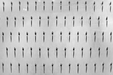 a white wall on which many forks are attached in a row, wall decoration ideas