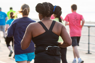 Rear view of African American female runner racing on a boardwalk
