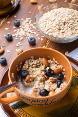 breakfasr with oatmeal porridge with blueberries, fruits,  almonds and coconut milk. Healthy and tasty vegan breakfast. top view, flat lay.
