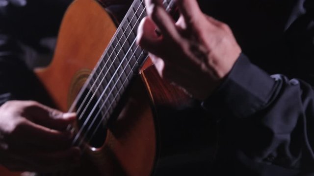 close-up of guitar strings and fretboard, guitarist playing an acoustic guitar