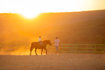 A father teaches his little son how to ride.