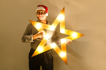 portrait of senior man in santa hat looking at camera and winking over light white background
