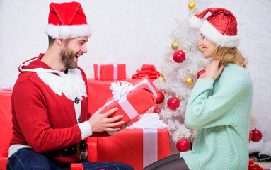 Couple in love enjoy christmas holiday celebration. Family prepared christmas surprise. Dreams come true. Opening christmas present. Loving couple smiling unpacking gift christmas tree background