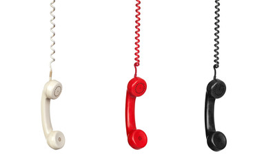 Black, white and red vintage phones hanging of a cable