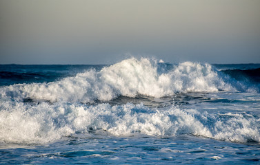 Dangerous wavy ocean with wind waves crashing.