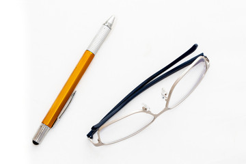 Fashion reading glasses and pen on white background