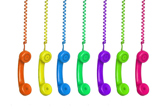 Manu colorful vintage phones hanging of a cable