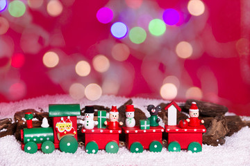trenecito de navidad en fo ando rojo y nevado, con luces en bokeh . Merry christmas y sin letrero