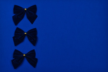Three blue bows on a blue background. 2020 trend. Color of the year.