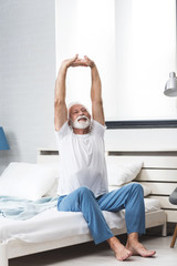 Senior man stretch on bed in morning