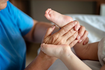 Baby having foot massage in a rehabilitation centre. Little child on therapy. Massage therapist massaging a baby patient.